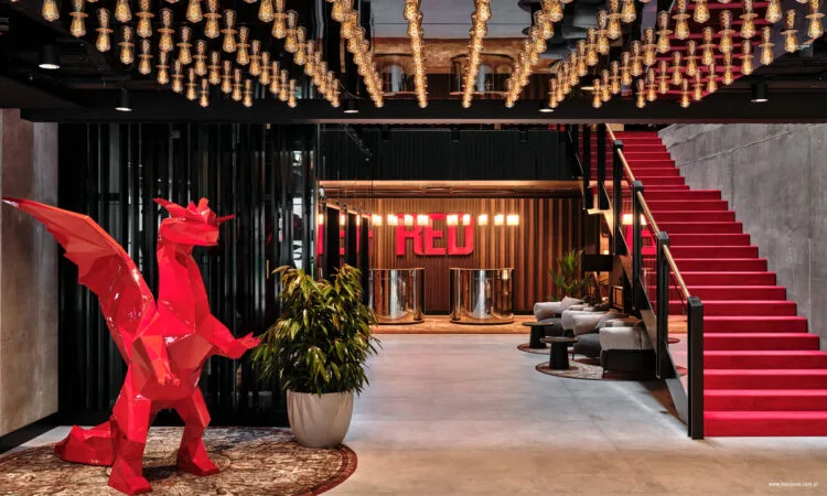 Lobby hotelu Radisson RED Kraków, instalacja świetlna z setek żarówek nad wejściem oraz rzeźba smoka.