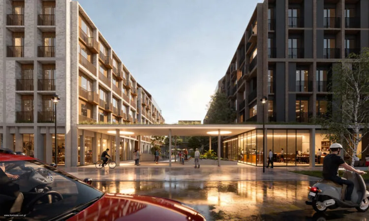 Wewnętrzny plac z zielonymi rabatami, pieszy pasaż między budynkami z usługami w parterach, światło wieczorne.