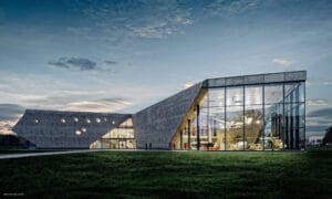 Muzeum Lotnictwa Polskiego w Krakowie, nowy budynek główny o formie przypominającej śmigło, beton architektoniczny i duże przeszklenia.